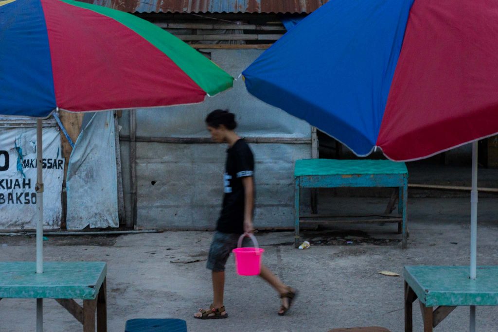 Una mujer transporta un cubo en un mercado de Indonesia