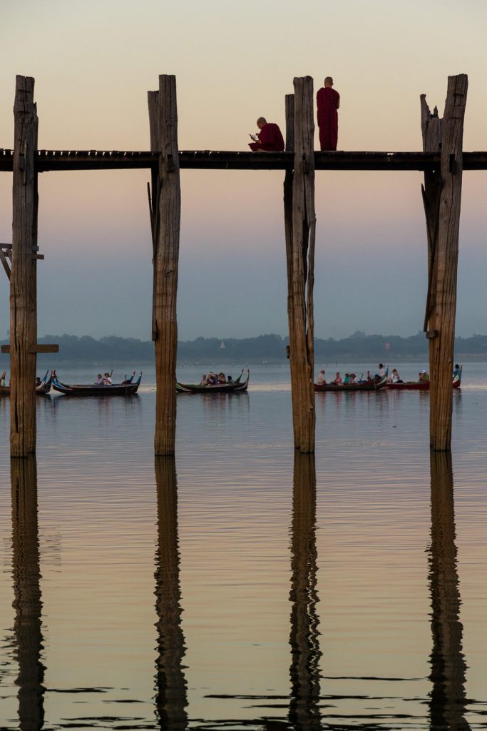 Atardecer en el puente de madera de U-Bein Myanmar (Birmania) con dos monjes sentados viendo el paisaje