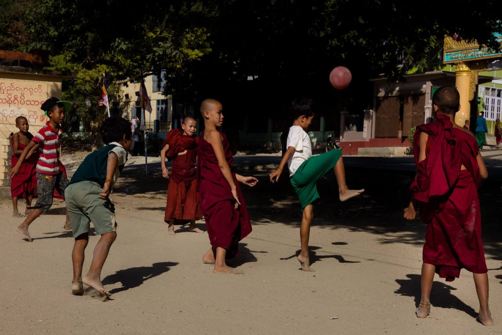 Niños jugando en un templo en Myanmar (Birmania) con monjes entre ellos