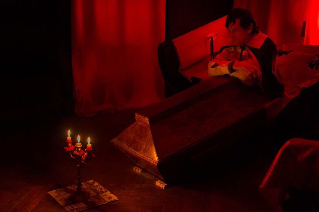 Un hombre sentado dentro de un ataúd caracterizado de Conde Drácula en el restaurante Drácula en Sighisoara Transilvania Rumanía